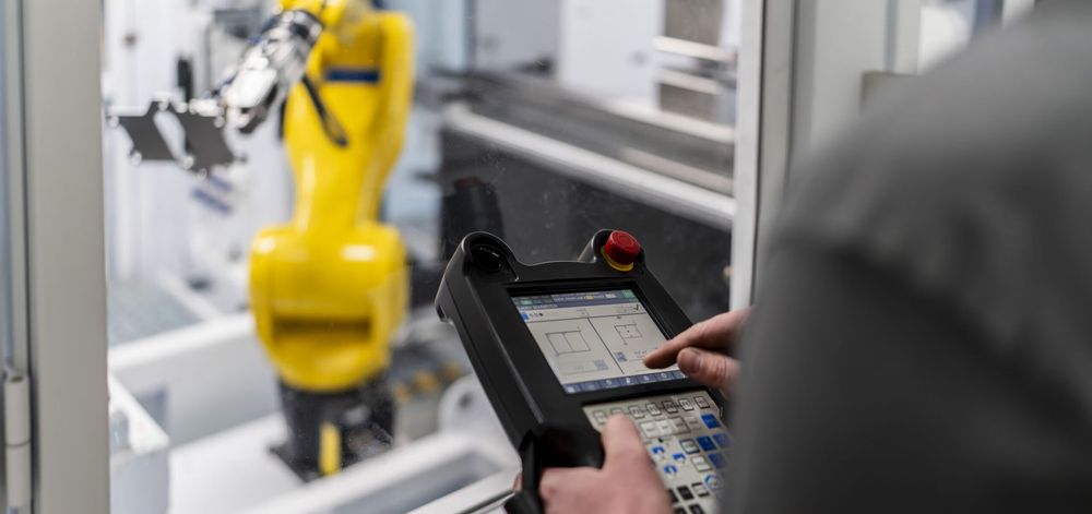 CLAAS operator programming the TRUMPF Flex Cell robot using a handheld control panel