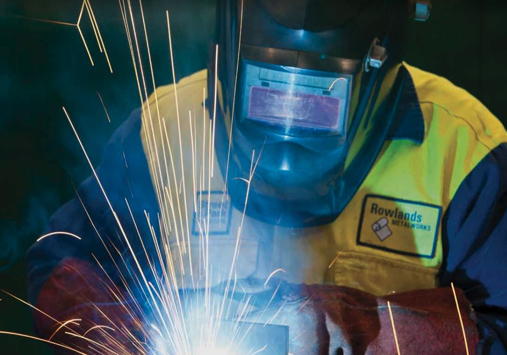 Rowland Metalworks employee grinding on shop floor